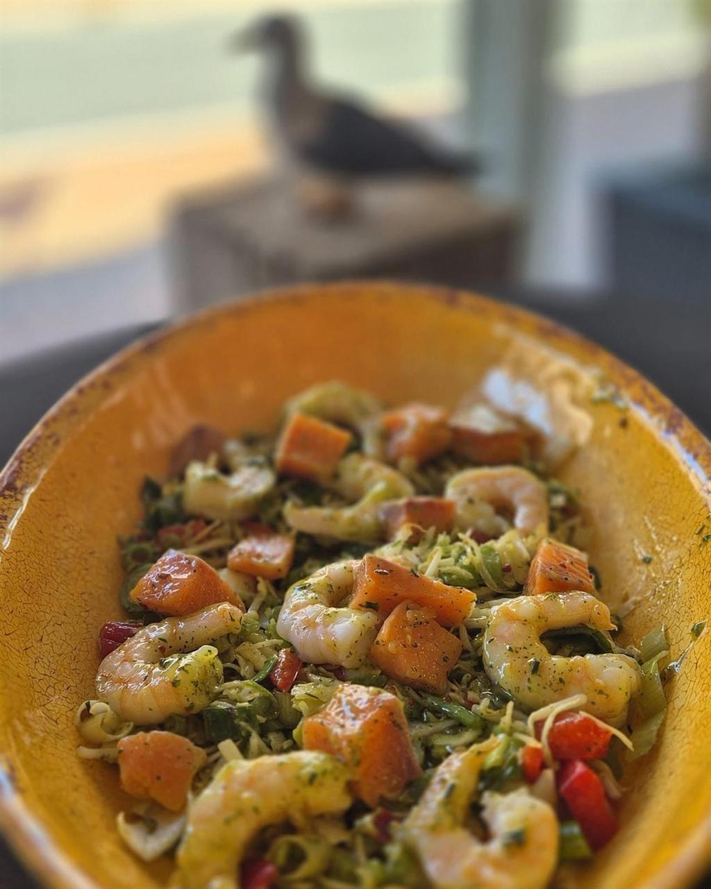 Salade met garnalen en zalm in een gele schaal